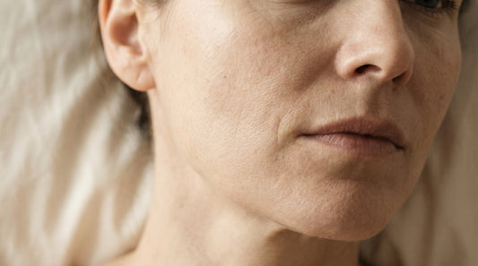 Glass dropper bottle of bakuchiol oil serum on a beige stone surface — vegan retinol alternative from Firmly